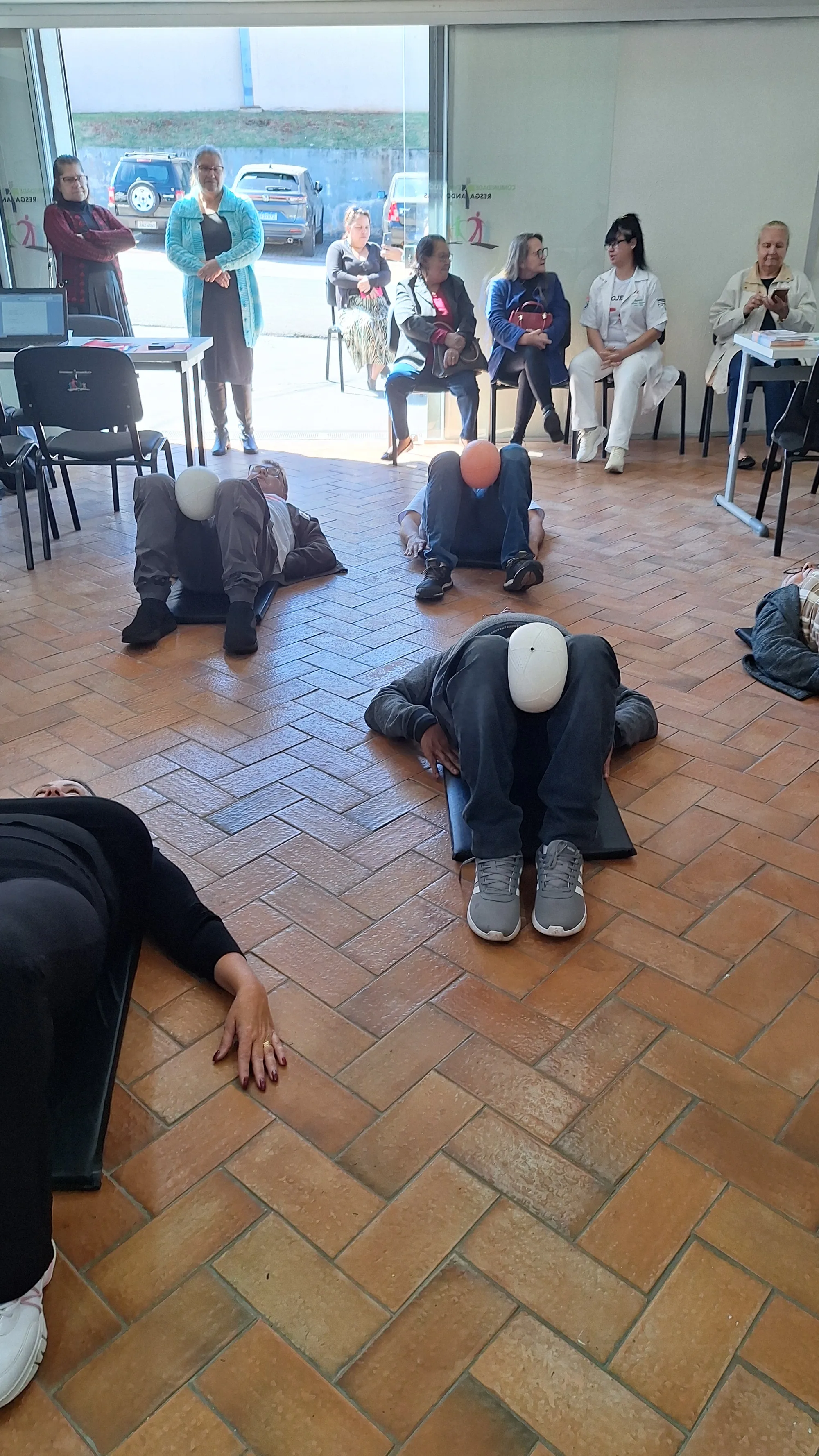 Participante alcançando uma bola durante exercício no chão.